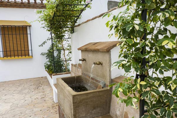 Detalle de fuente rústica en patio de casa rural: Constructora Málaga