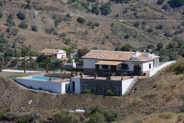 Vista desde lejos de casa rural con piscina: Constructora Málaga