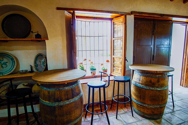 Interior apero bodega con barril y taburetes: Rehabilitación casas rústicas en Málaga